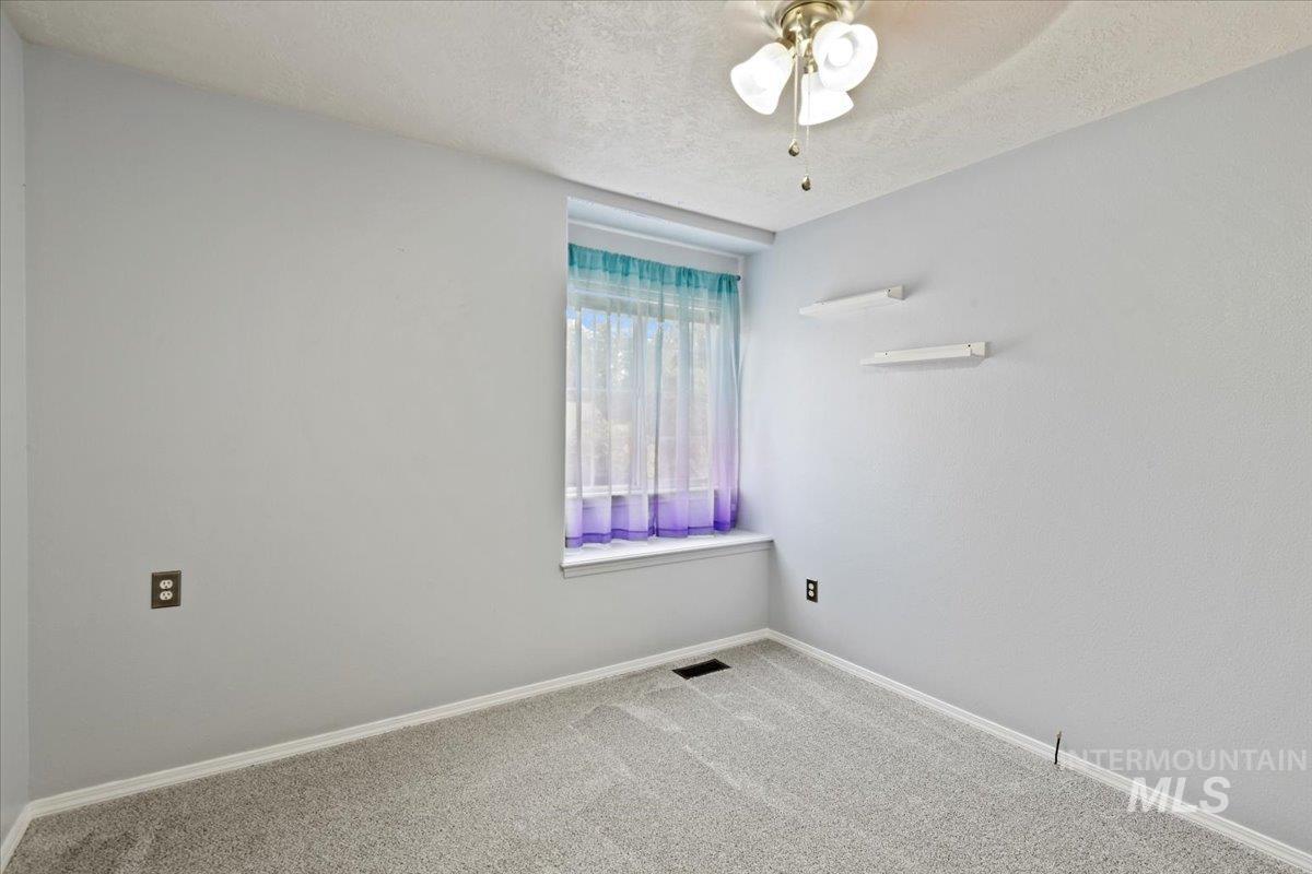 Upstairs bedroom with new carpet and fan with bench seating at window