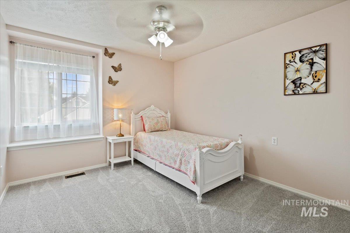 Upstairs bedroom featuring new carpet, fan and bench window seating