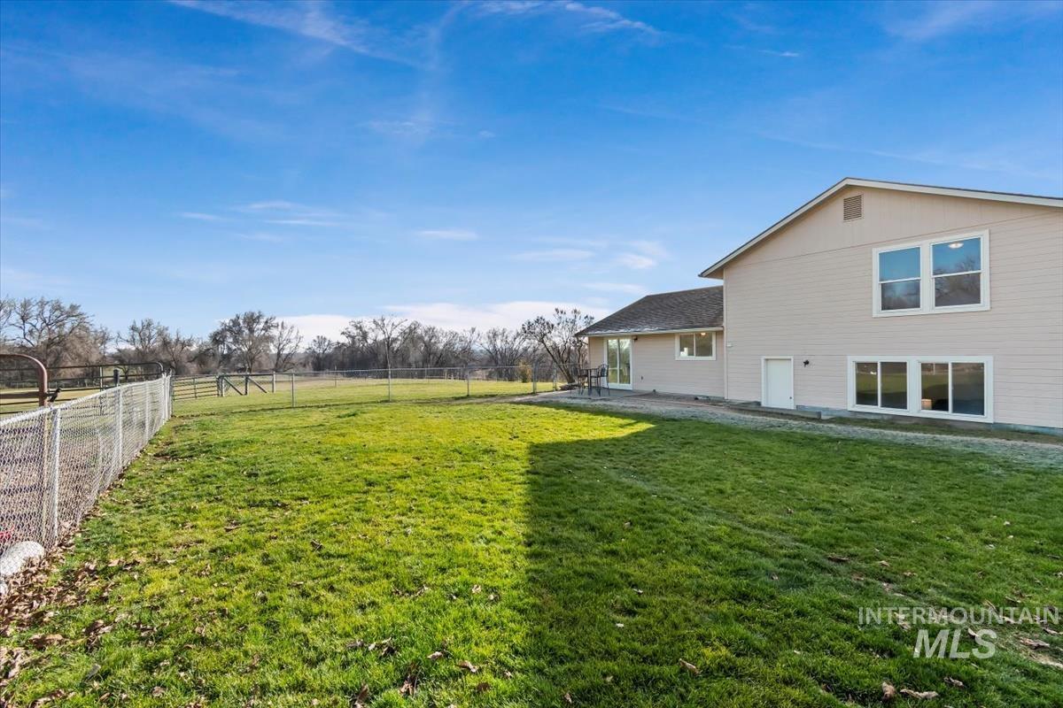 Fenced backyard with a view of the acreage