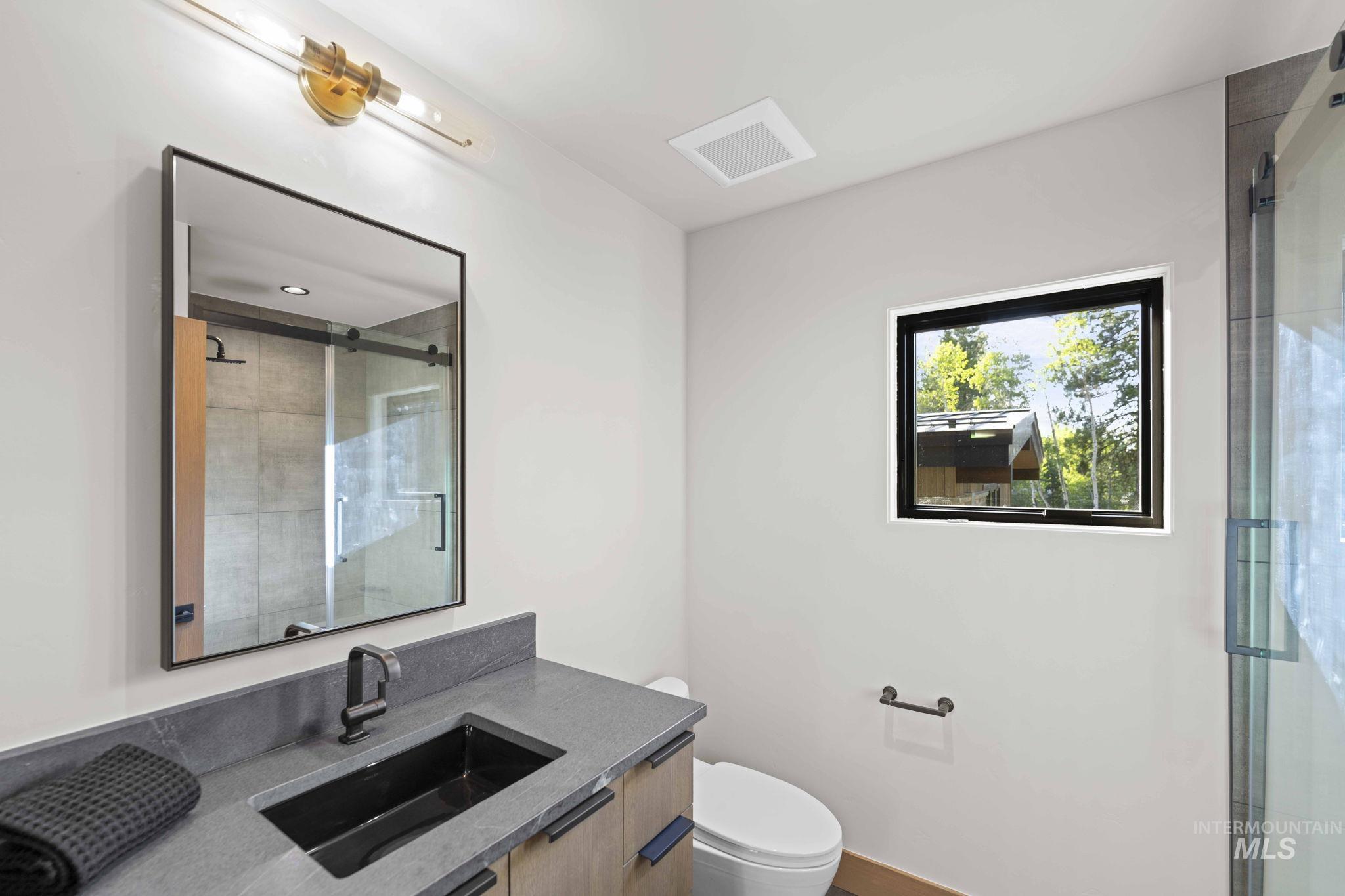 Full bath featuring a stall shower and vanity
