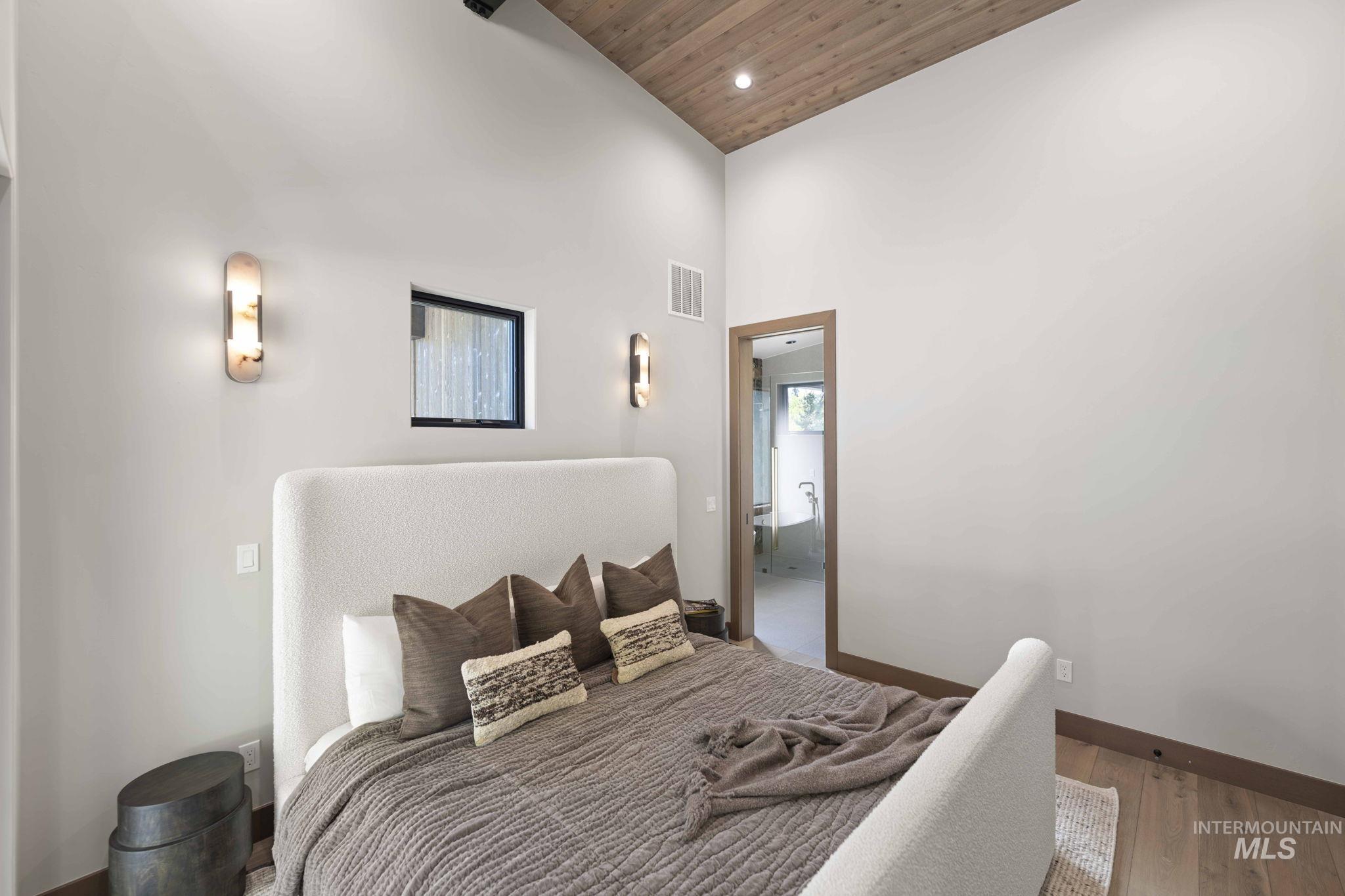 Bedroom with a high ceiling, wood finished floors, wooden ceiling, and recessed lighting