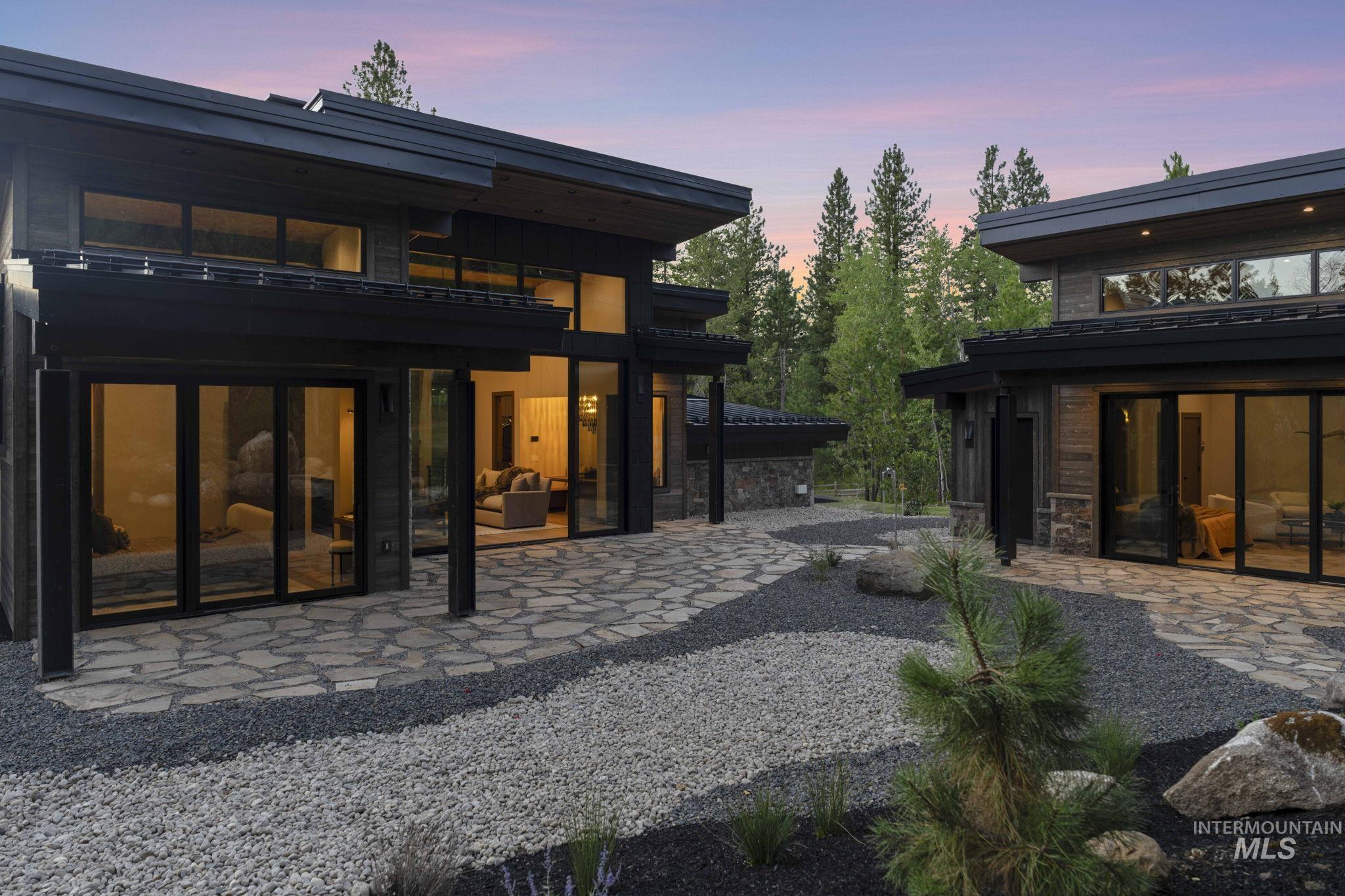 Rear view of property with a balcony, a patio, and stone siding