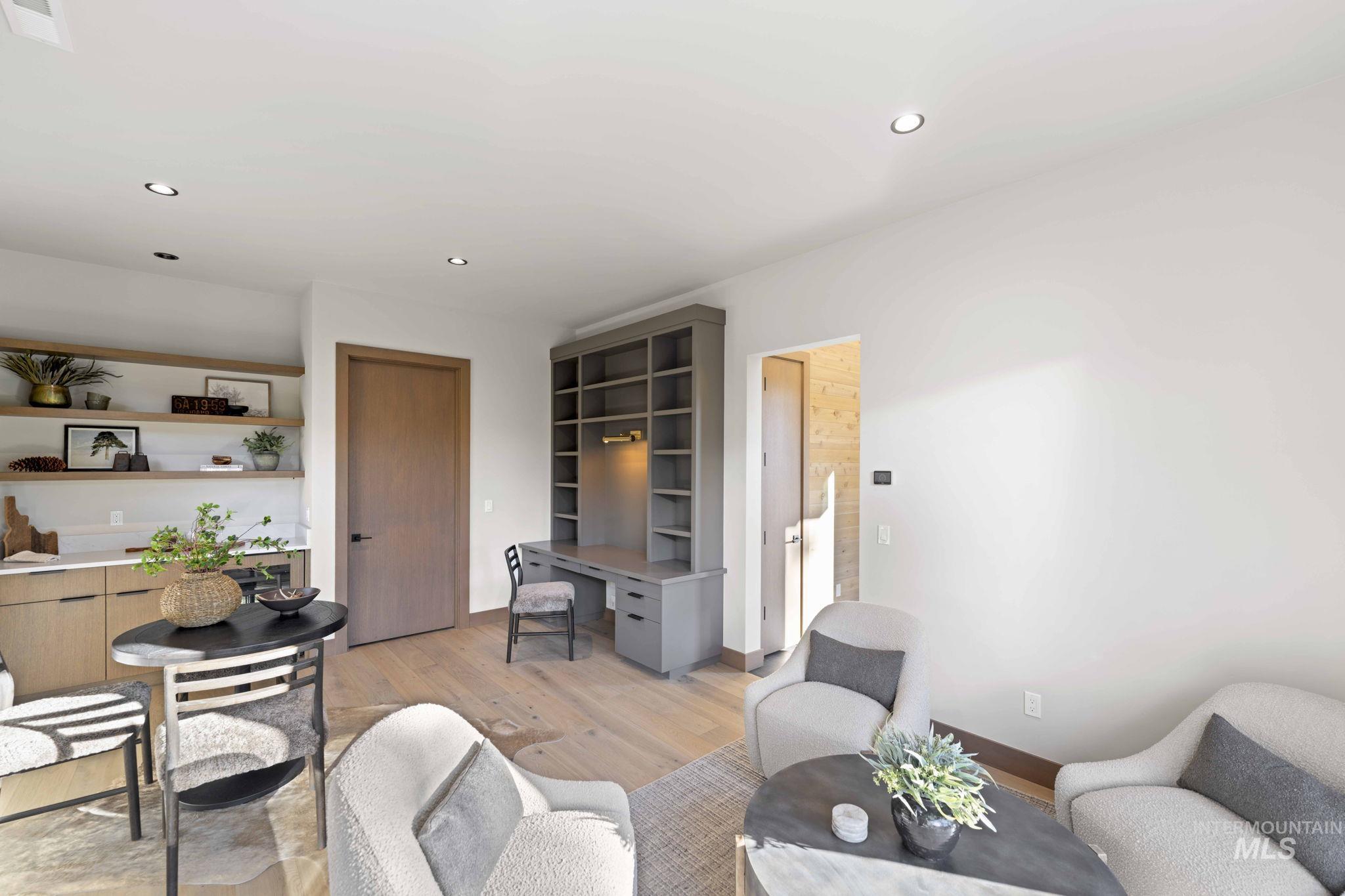 Living area with light wood-type flooring, an office area, and recessed lighting