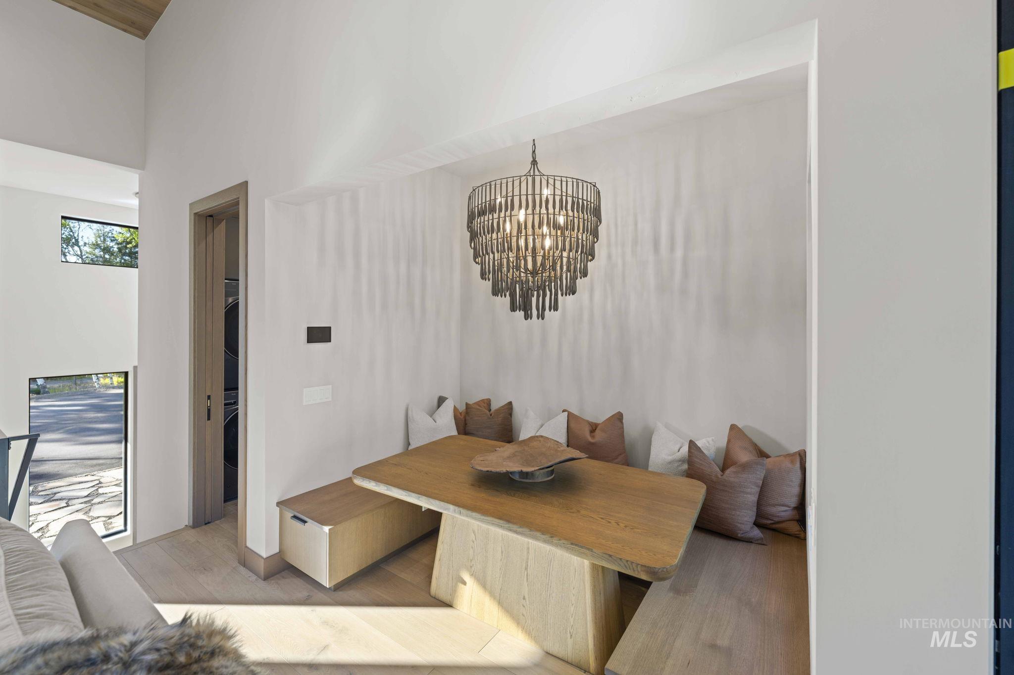 Dining area featuring light wood-style floors, a high ceiling, and a chandelier
