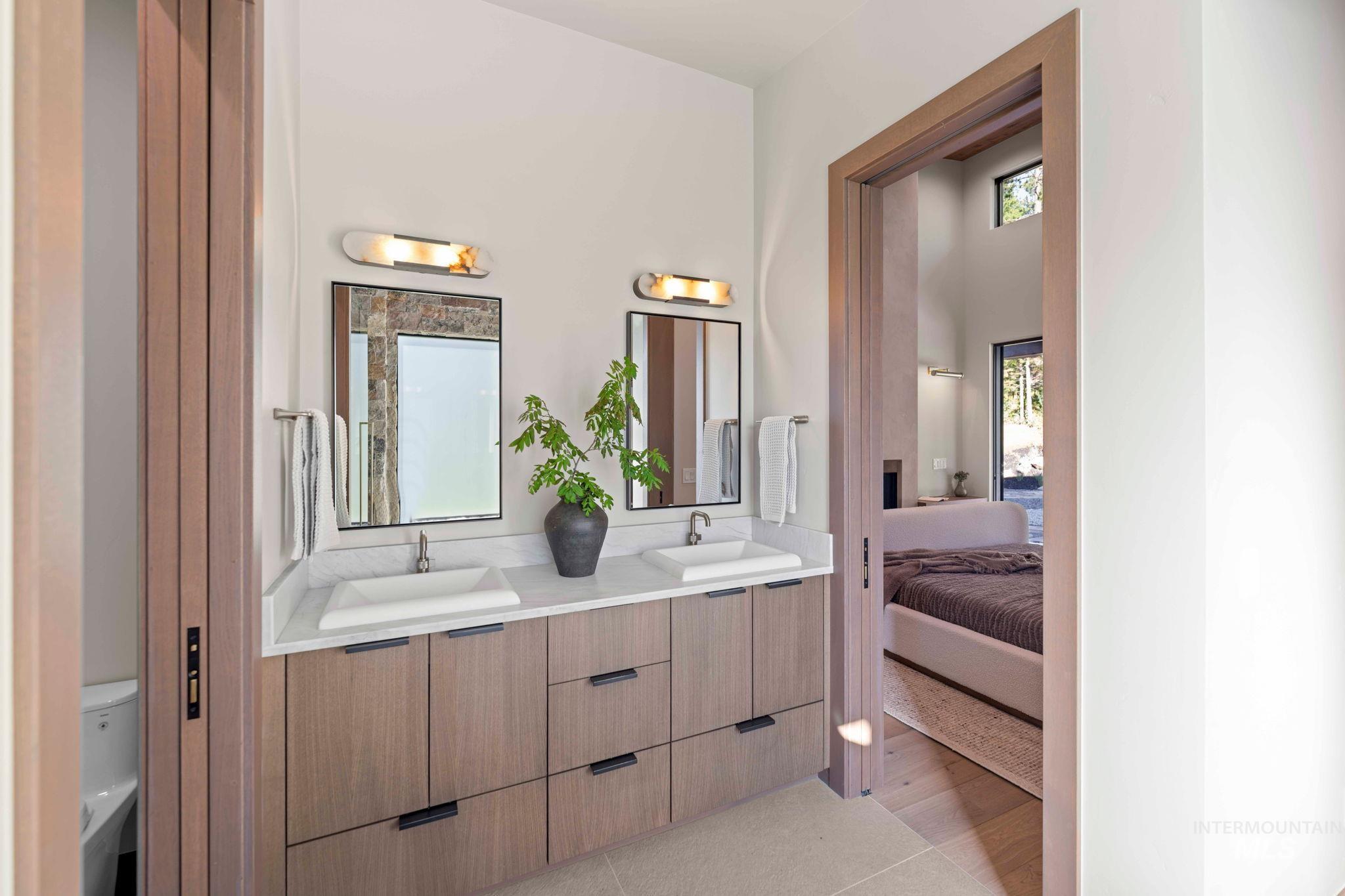 Bathroom featuring ensuite bath, double vanity, and tile patterned flooring