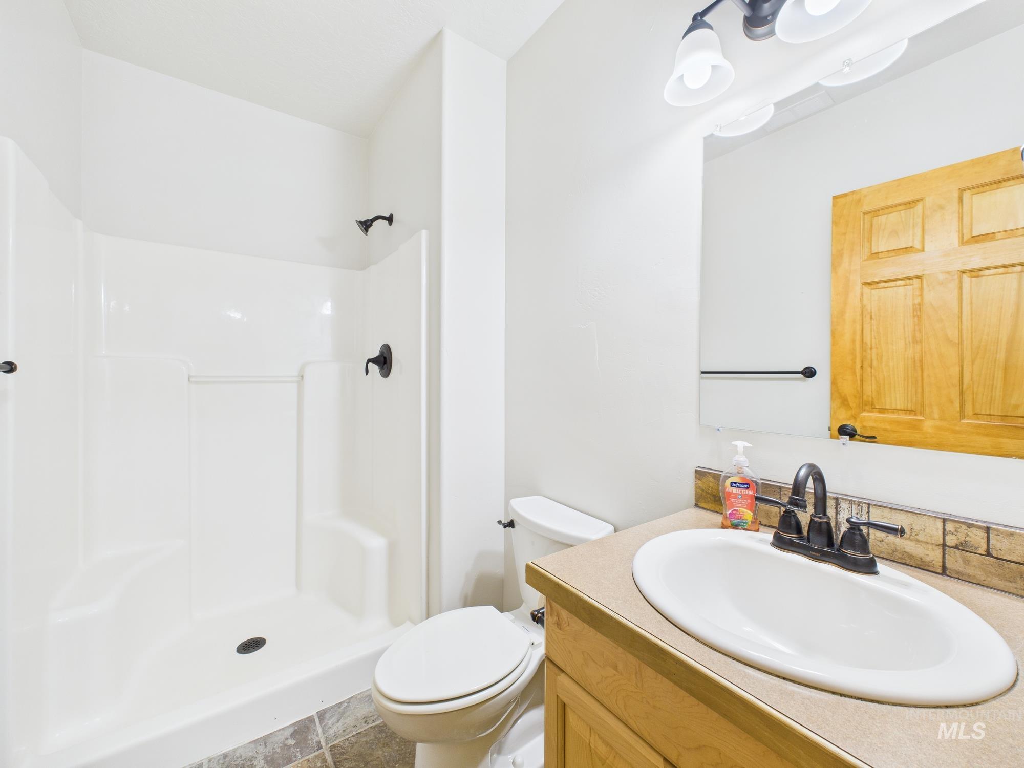 Full bath with vanity and a shower stall