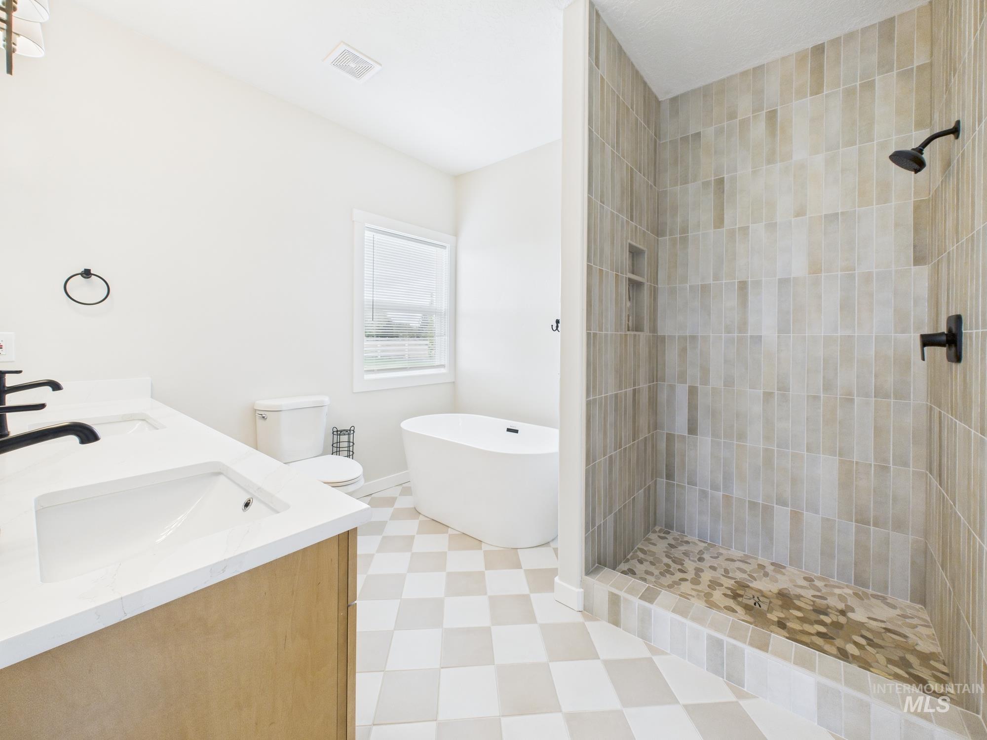 Bathroom with a shower stall, a freestanding bath, and double vanity