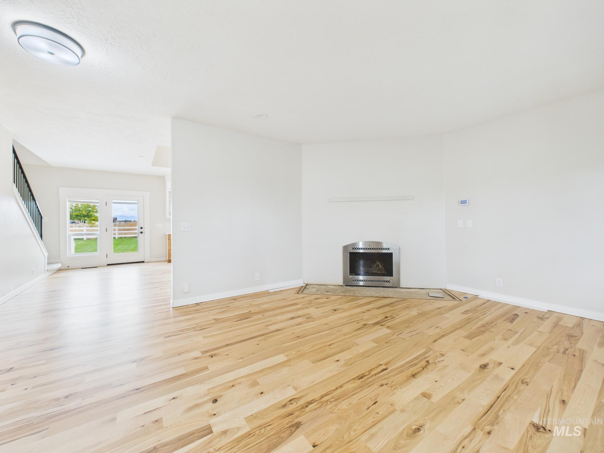 Unfurnished living room with light wood finished floors and a fireplace
