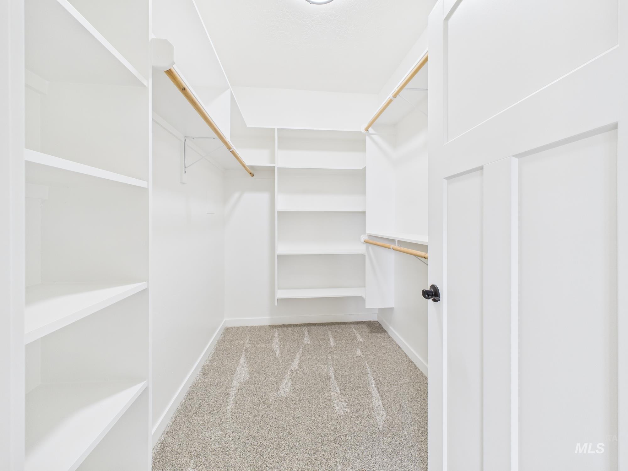 Spacious closet with light colored carpet