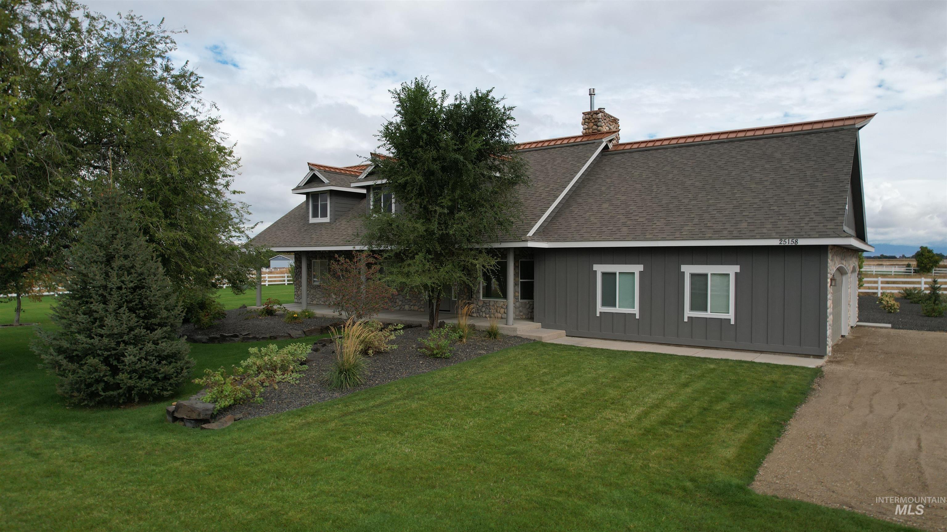 Back of house featuring board and batten siding, a yard, roof with shingles, and a chimney