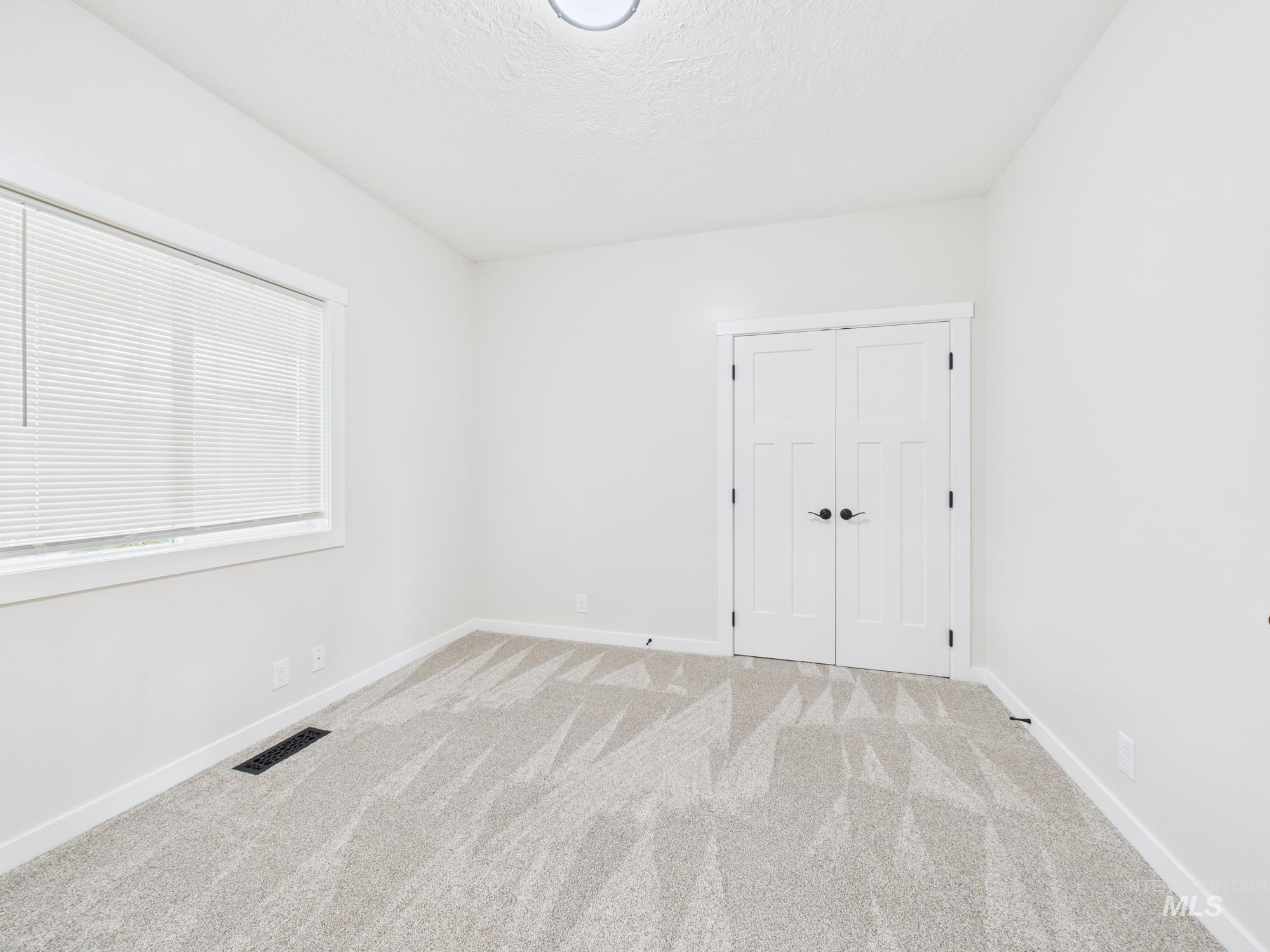 Unfurnished bedroom with carpet, a textured ceiling, and a closet