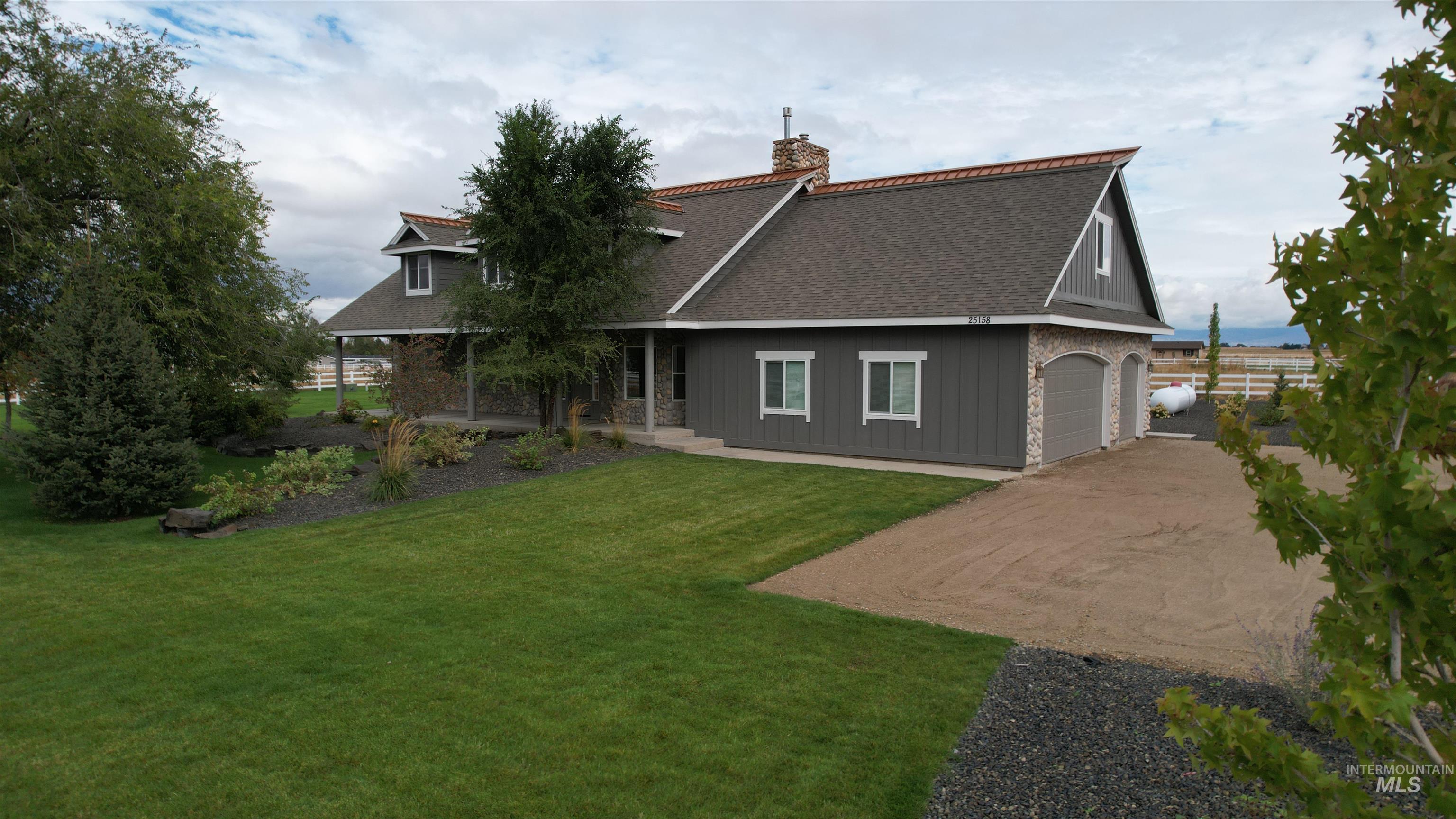 Back of house with a shingled roof, decorative driveway, a garage, and board and batten siding