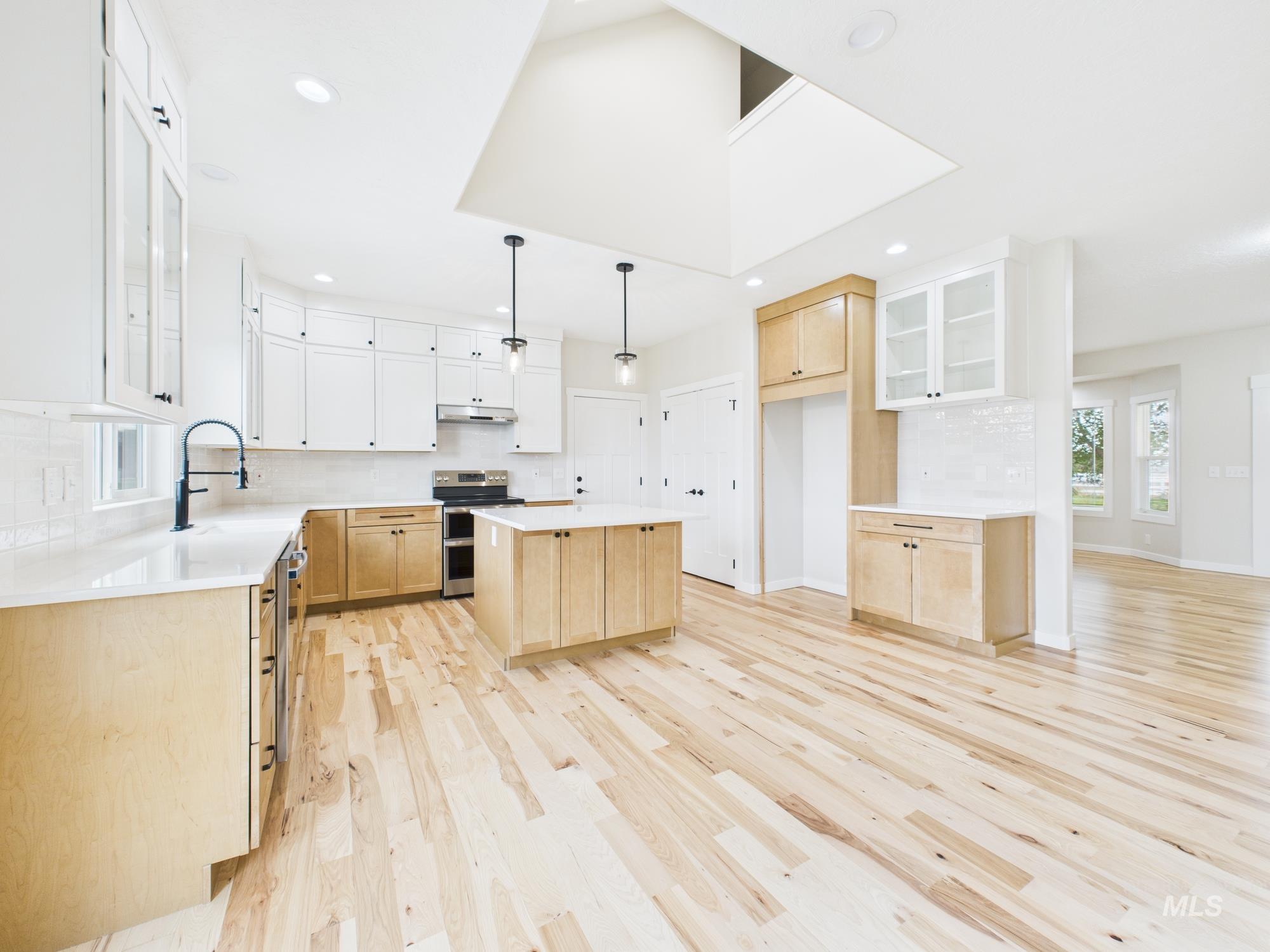 Kitchen featuring backsplash, glass insert cabinets, light brown cabinets, plenty of natural light, and recessed lighting