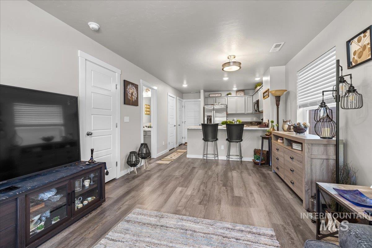 Living area with dark wood-style flooring and baseboards