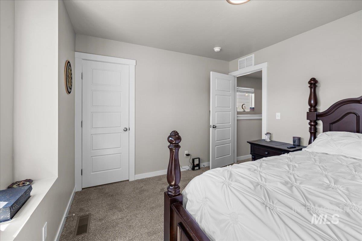 Bedroom with dark colored carpet and baseboards