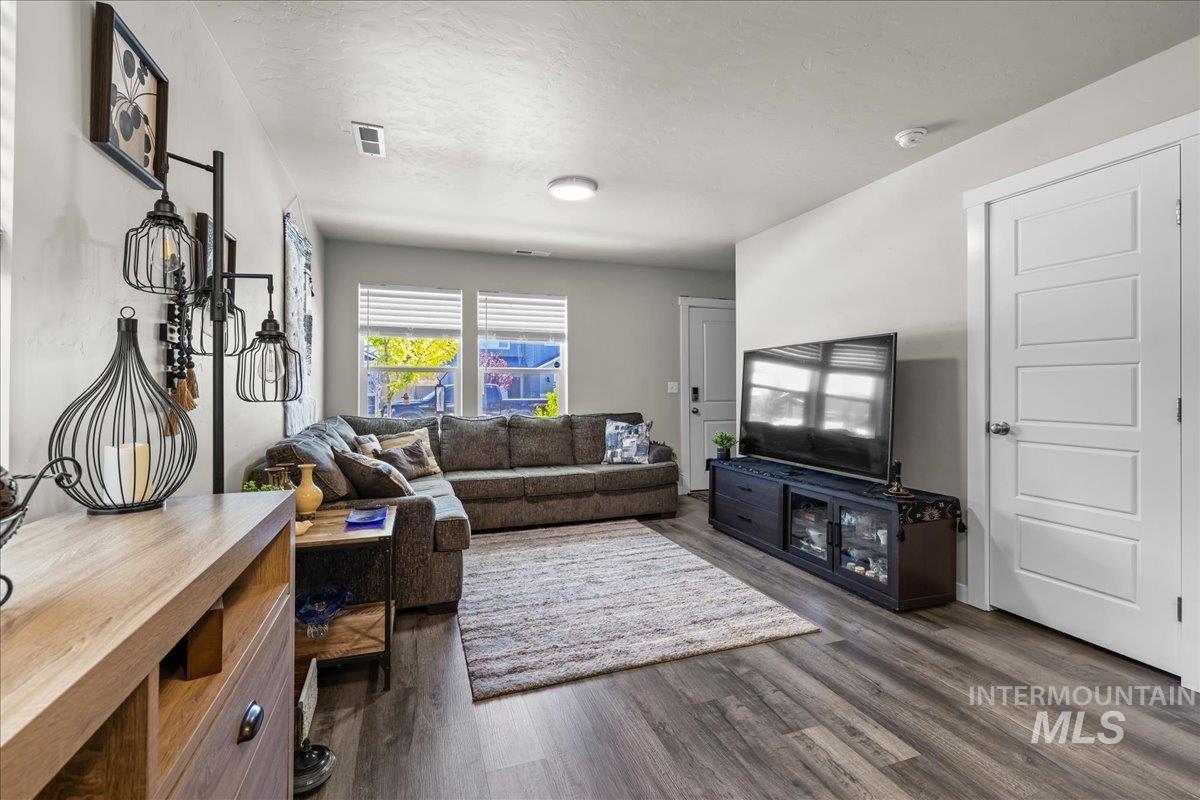 Living room featuring dark wood-type flooring and a textured ceiling