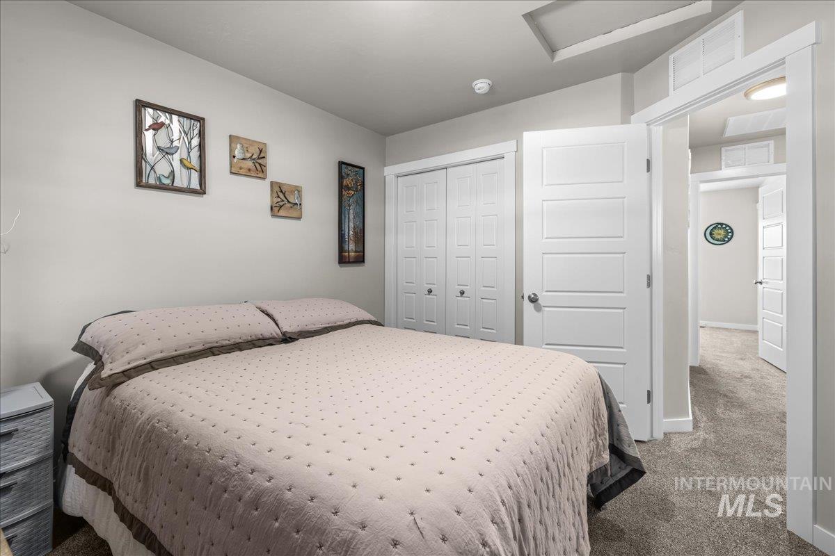 Bedroom with attic access, carpet flooring, and a closet