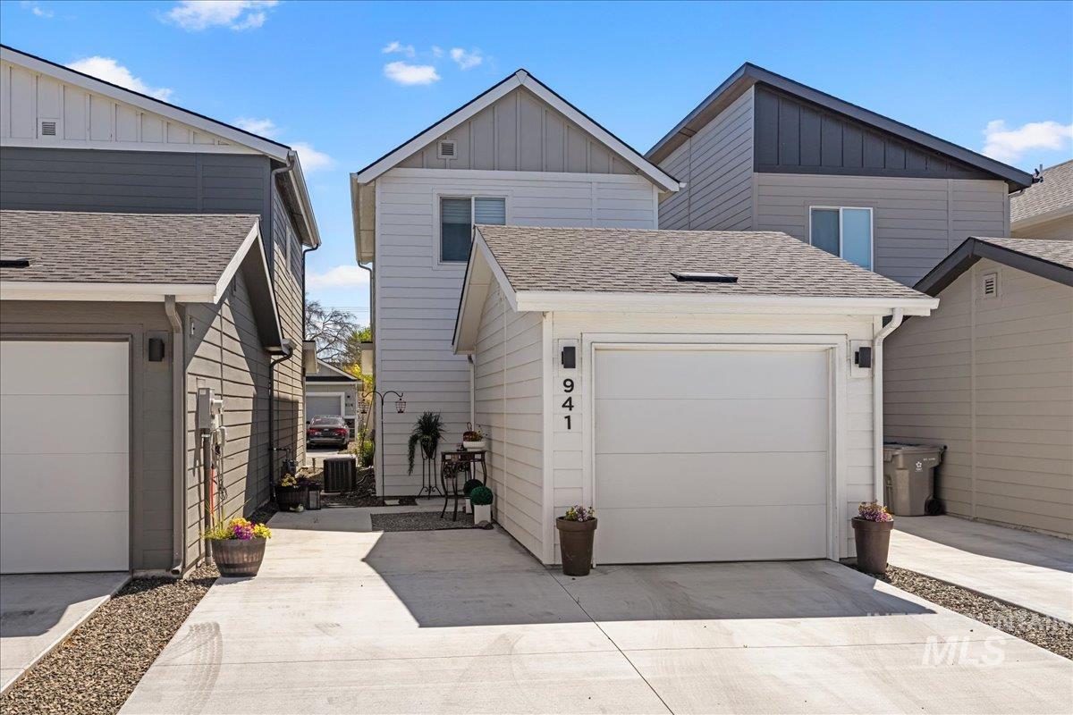 View of front of property featuring a shingled roof, concrete driveway, board and batten siding, and a garage