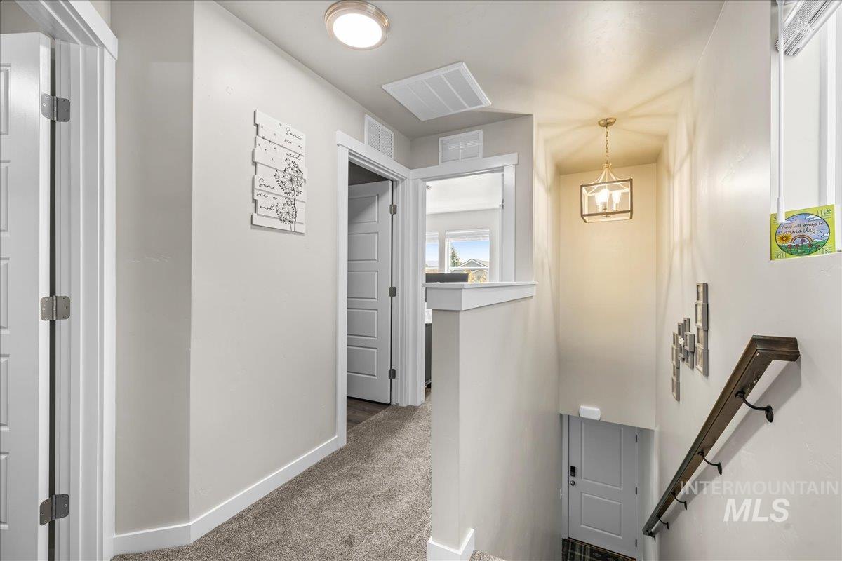 Hall featuring an upstairs landing and carpet floors