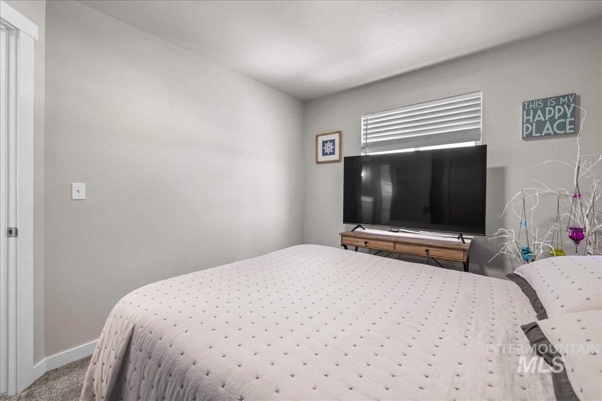 Bedroom featuring carpet and baseboards