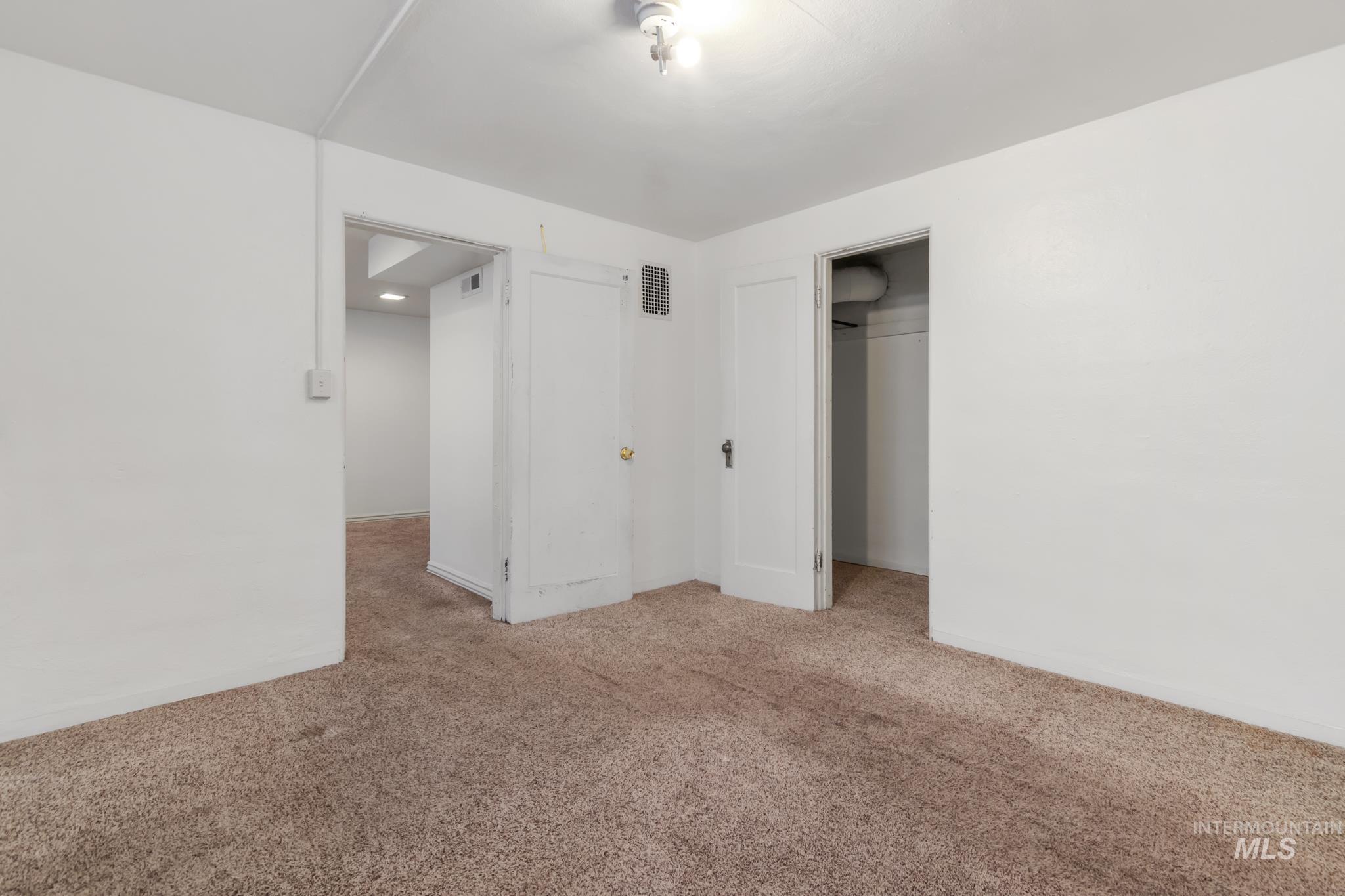 Carpeted interior space with white walls