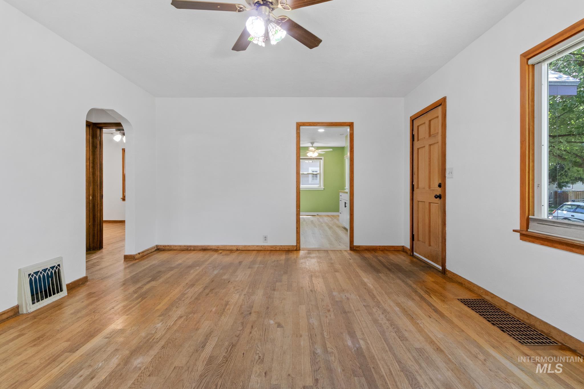 Expansive interior space featuring wood-finish flooring, white painted walls, and wood trim