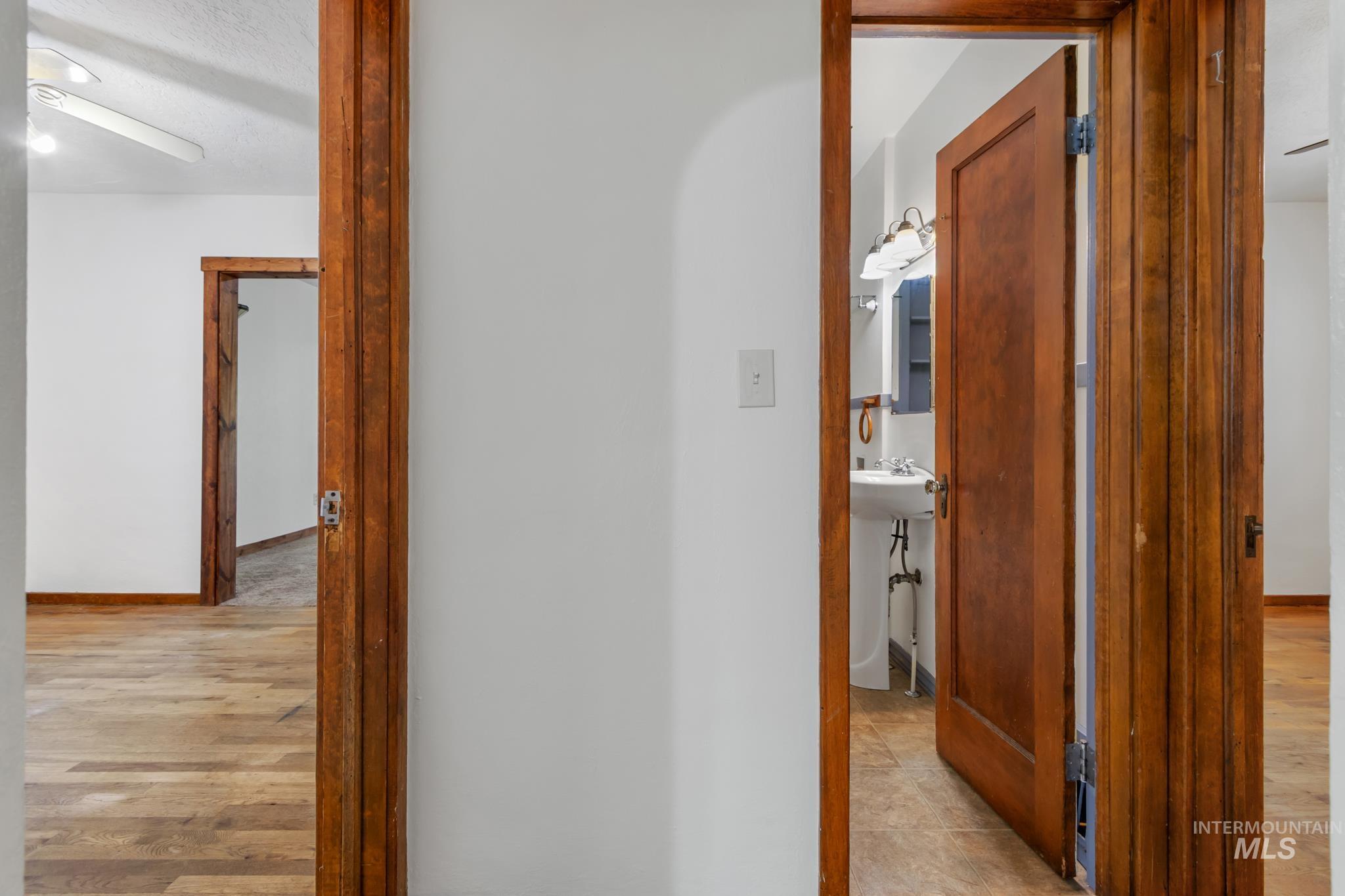 White walls and warm wood-finish flooring characterize this interior space