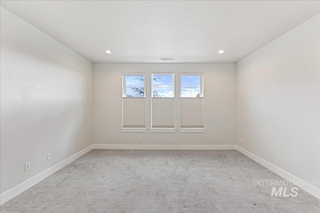 Spare room featuring light carpet and recessed lighting