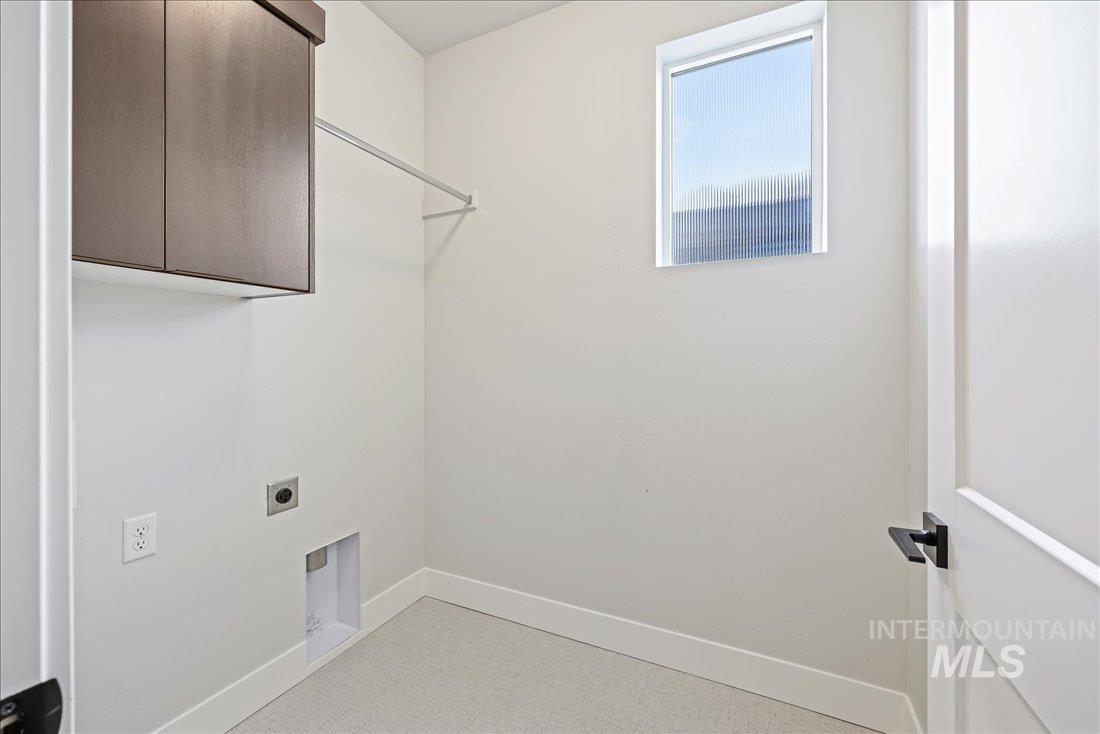 Laundry area featuring electric dryer hookup and cabinet space