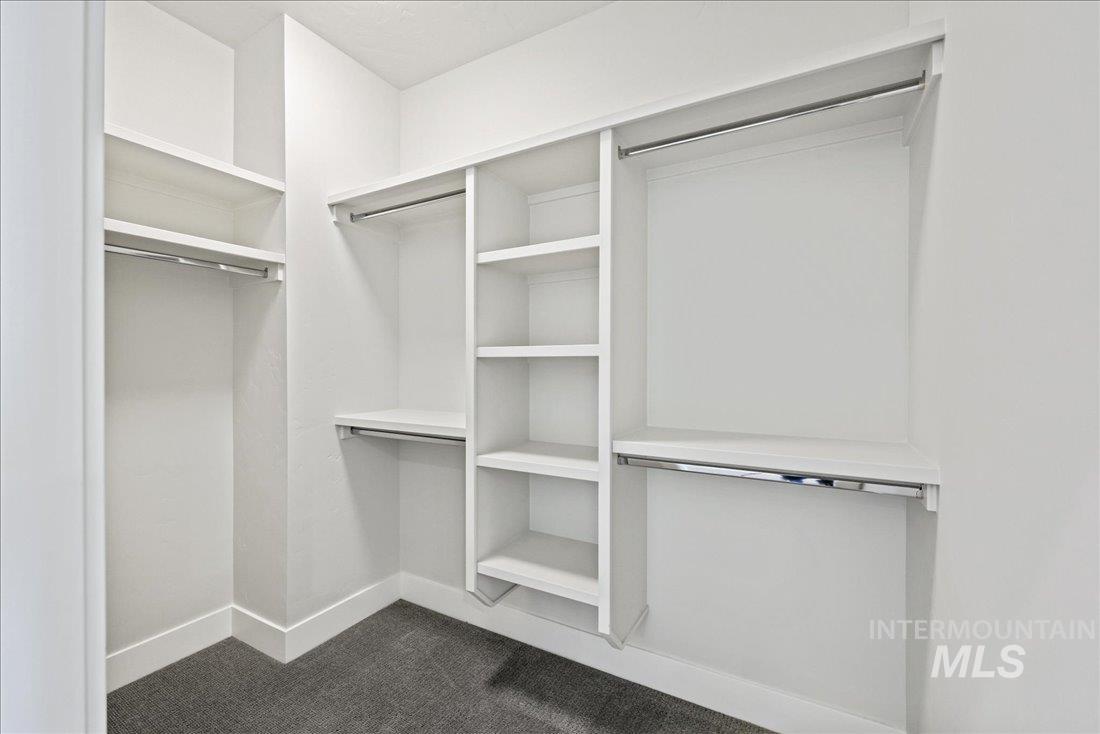 Walk in closet featuring dark carpet