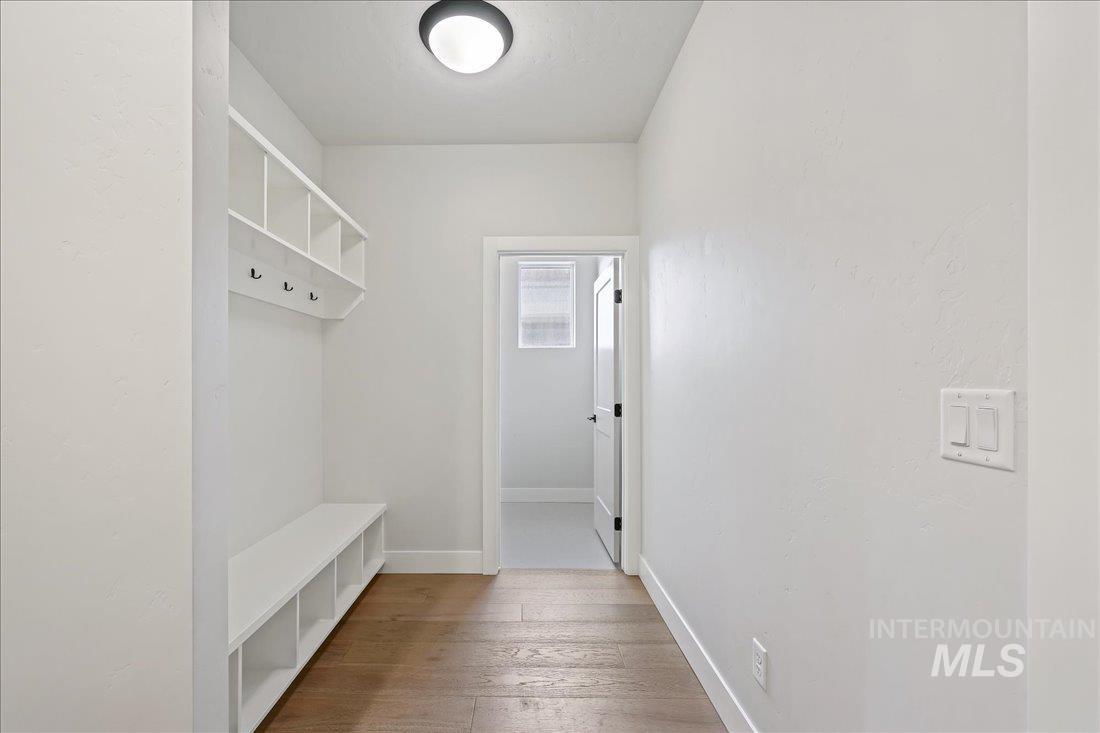 Mudroom with light wood-style flooring and baseboards