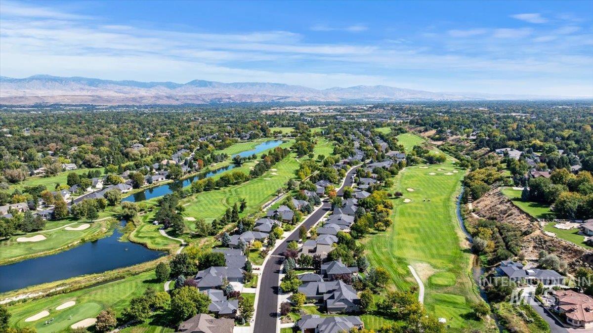 Aerial overview of property's location featuring a water and mountain view and nearby suburban area