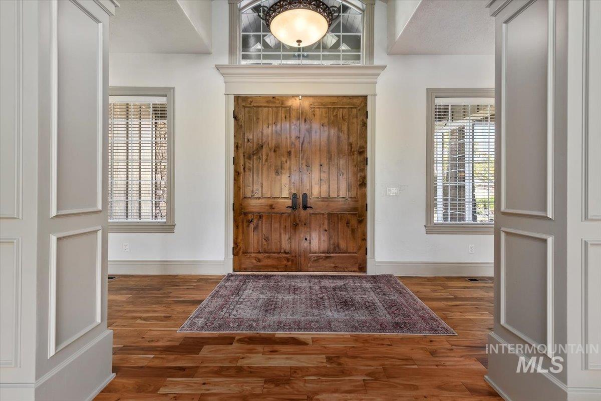 Foyer with baseboards and wood finished floors