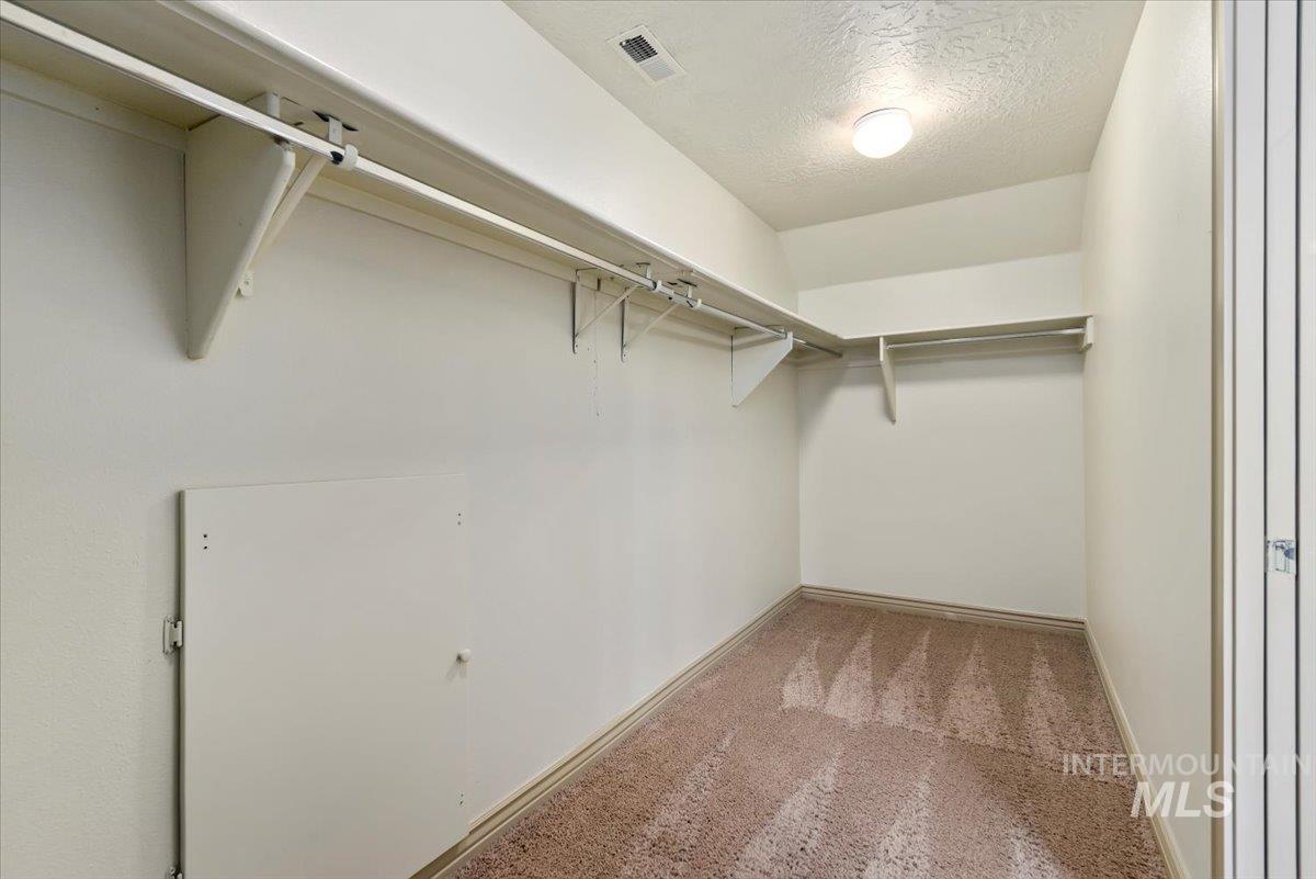 Walk in closet featuring light carpet