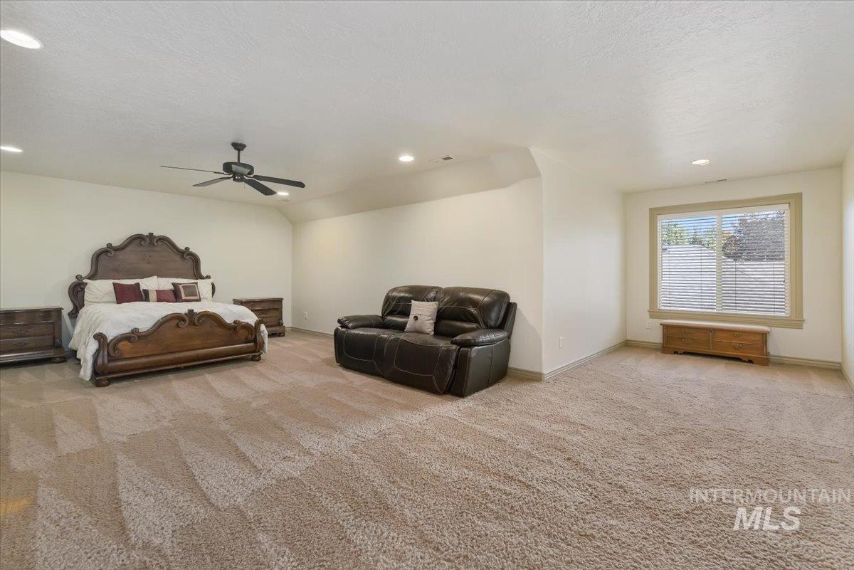 Bedroom with light carpet, recessed lighting, a ceiling fan, a textured ceiling, and vaulted ceiling
