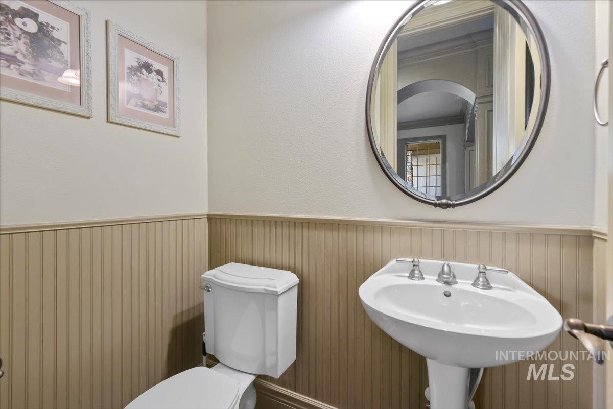 Bathroom with a wainscoted wall and crown molding
