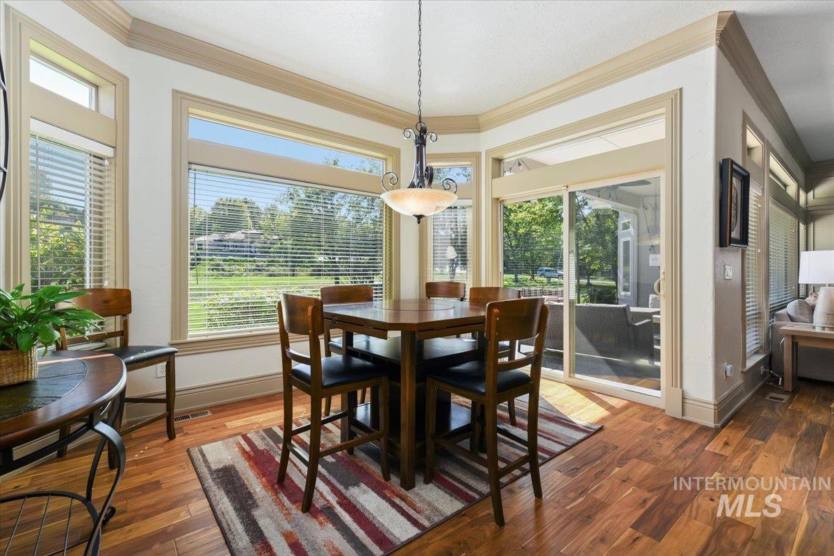Dining area with wood finished floors and ornamental molding