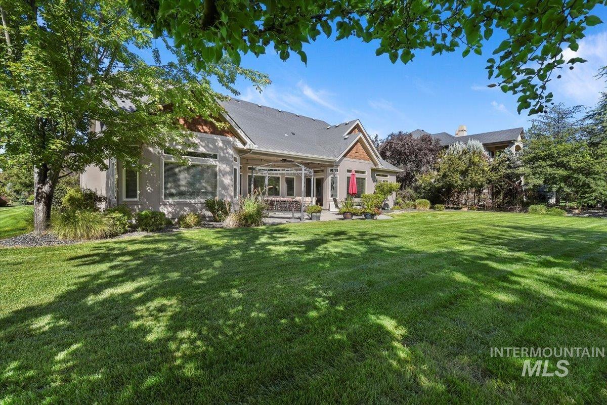 Rear view of property featuring a ceiling fan, a yard, and covered porch