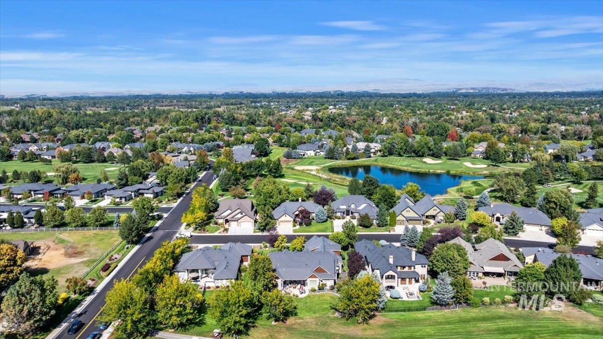 Aerial view of residential area featuring a nearby body of water and a golf course