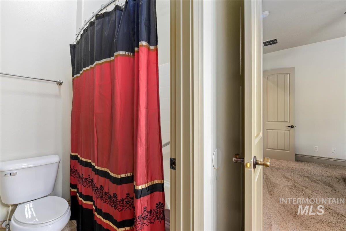 Bathroom featuring toilet and a shower with shower curtain