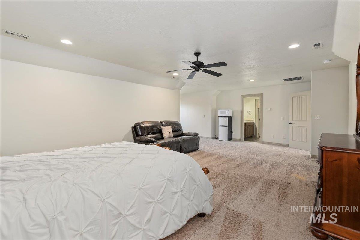 Bedroom featuring carpet floors, recessed lighting, connected bathroom, ceiling fan, and freestanding refrigerator