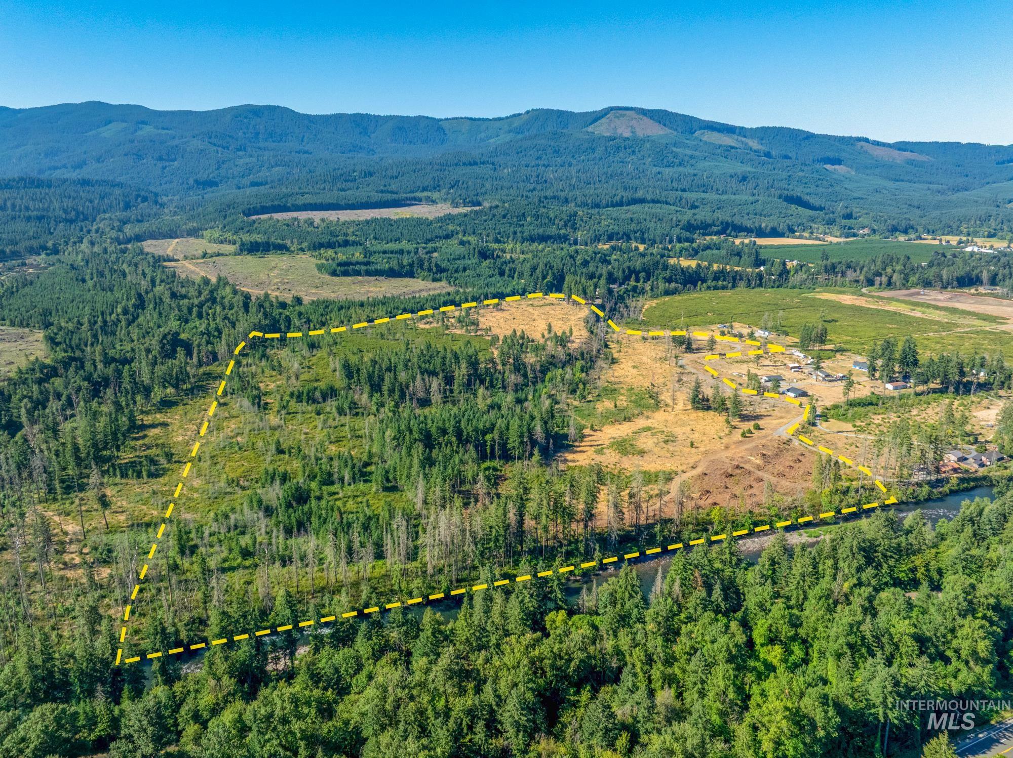 Aerial view of property's location with property parcel outlined and a mountain backdrop