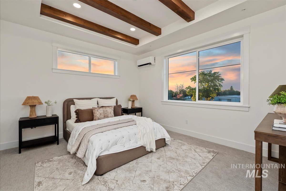 Bedroom with beamed ceiling, light carpet, a wall mounted air conditioner, and recessed lighting