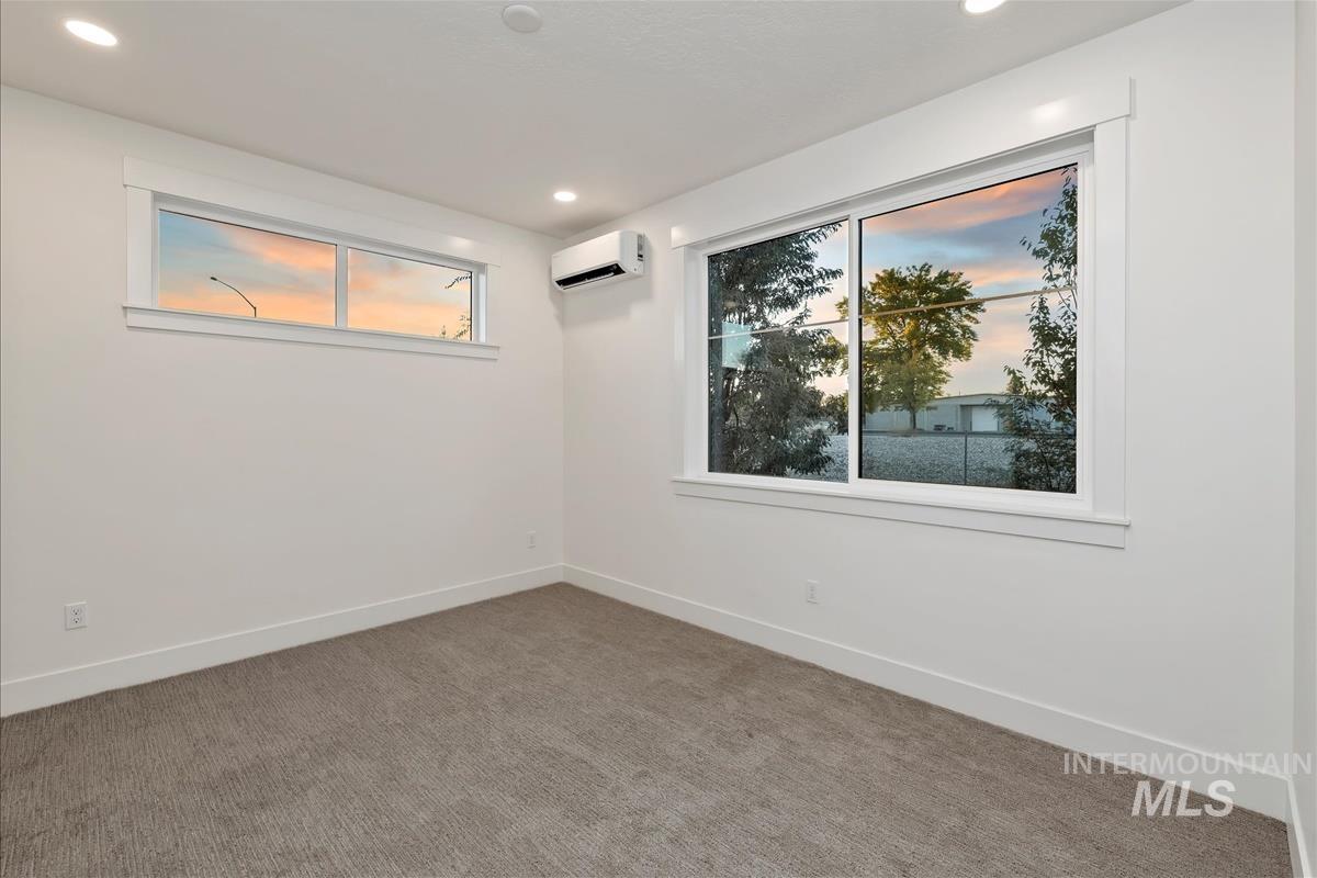 Unfurnished room with carpet flooring, recessed lighting, and a wall mounted air conditioner