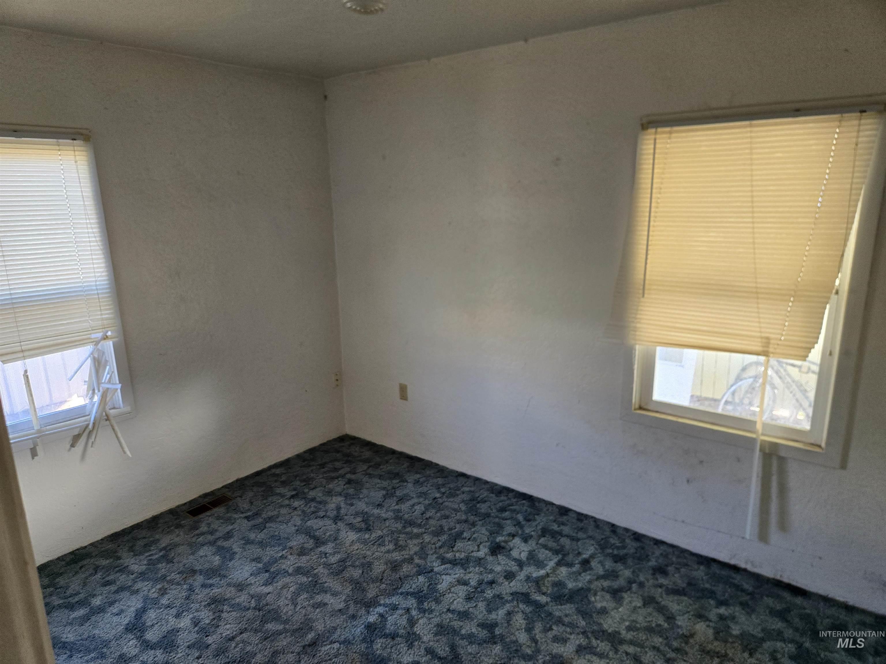 Spare room featuring dark carpet