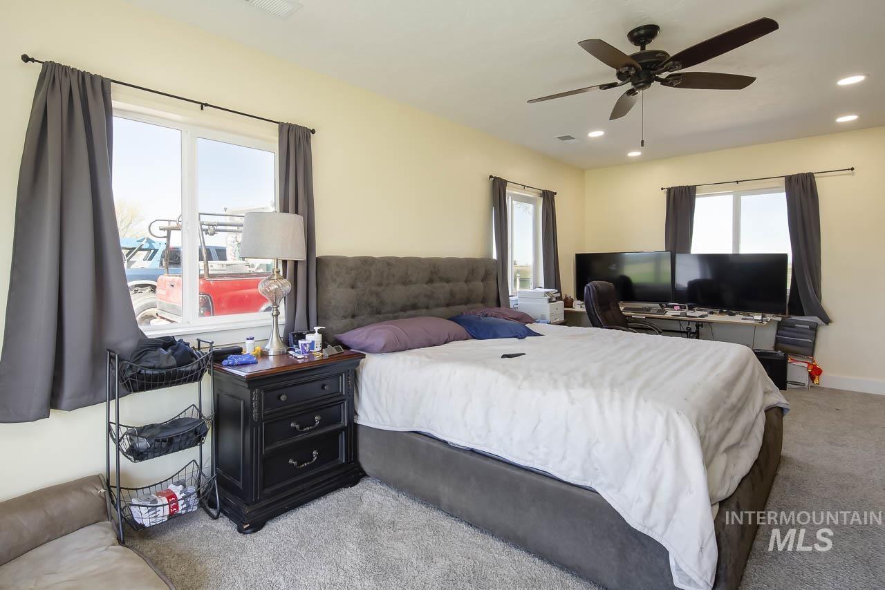 Bedroom with light colored carpet, recessed lighting, and a ceiling fan
