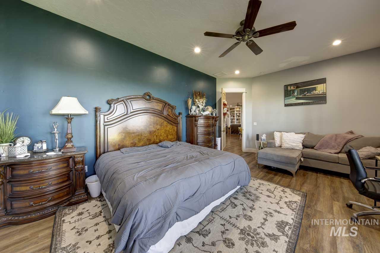 Bedroom with wood finished floors, a ceiling fan, and recessed lighting