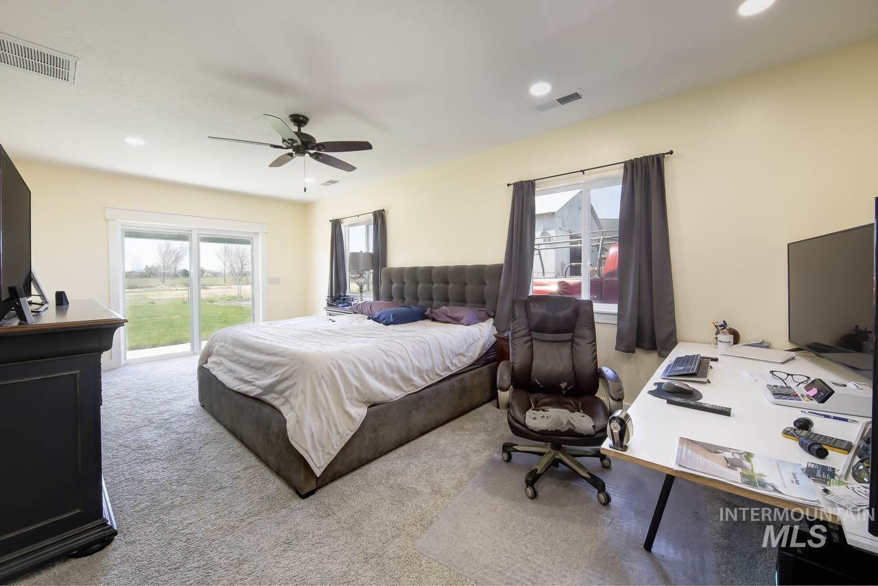 Carpeted bedroom with multiple windows, access to outside, an office area, and recessed lighting