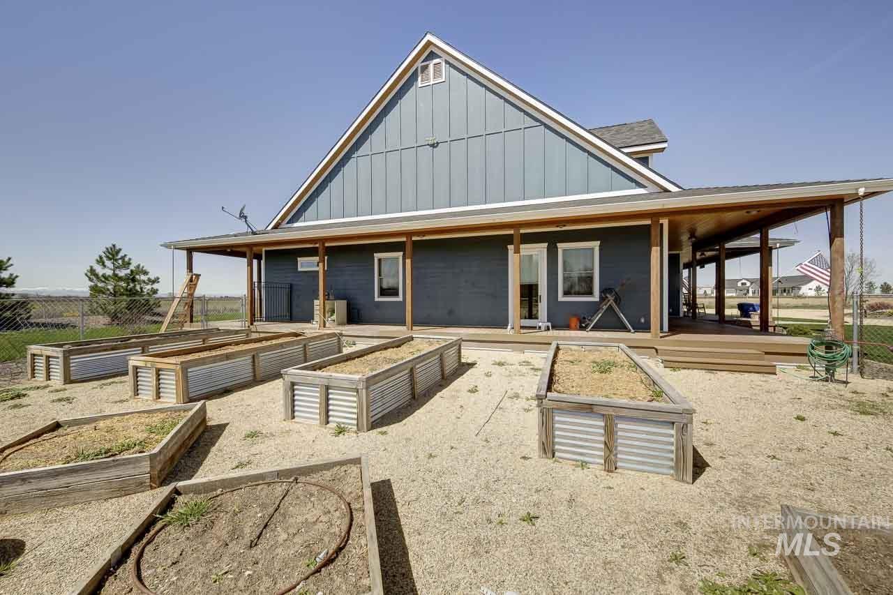 Back of property with board and batten siding and a garden