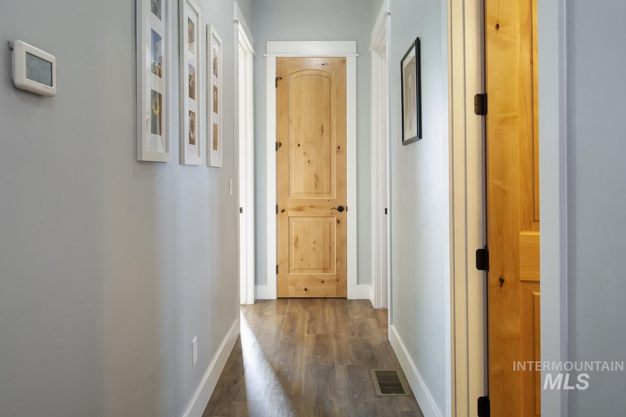 Hallway featuring baseboards and dark wood-style floors
